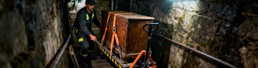 Professionnel évacuant meuble volumineux cave humide, escaliers étroits et contraintes d'accès