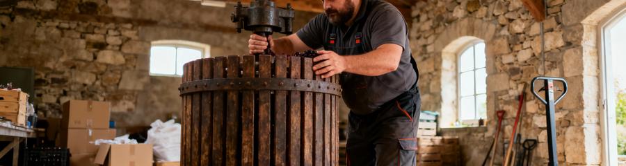 Professionnel débarrassant ancien pressoir viticole, manipulation équipement agricole lourd Champagne