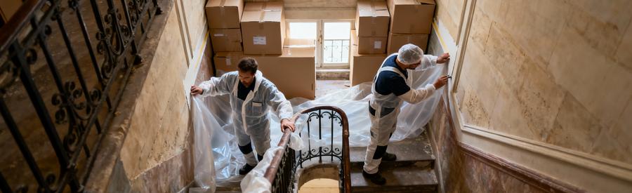 Débarrasseurs protégeant escalier ancien immeuble parisien avant évacuation mobilier