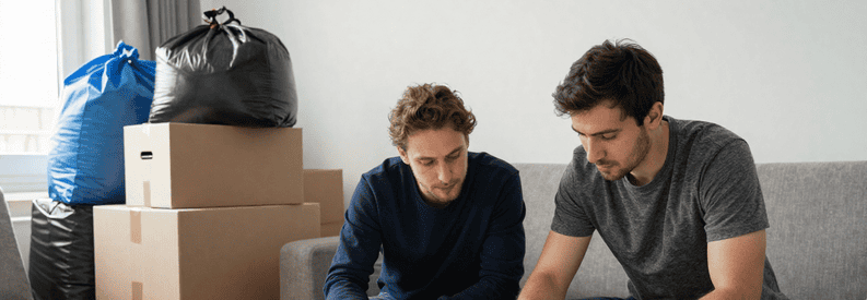 Client comparant plusieurs offres papier avec débarrasseur professionnel dans salon encombré à Asnières