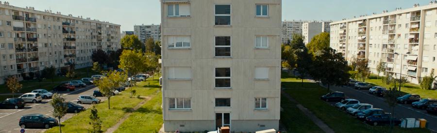 Vue aérienne quartier 4000 La Courneuve avec camionnette débarrasseur devant immeuble, intervention locale 93120