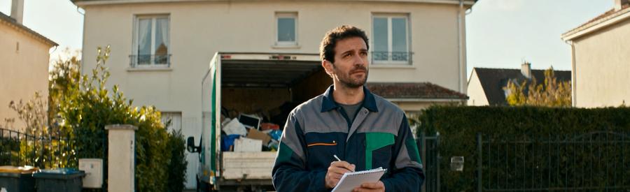 Debarrasseur Professionnel Evaluation Maison Bezons Débarrasseur professionnel évaluant une intervention devant une maison à Bezons avec sa camionnette de service