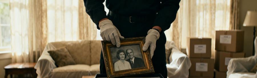 Debarrasseur Professionnel Succession Villiers Le Bel Professionnel manipulant avec soin des objets personnels lors d'un vide-maison après succession à Villiers-le-Bel