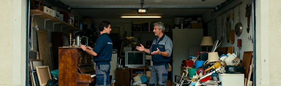 Deux professionnels analysent des meubles dans un garage avant de comparer leurs offres de débarras à Vandœuvre-lès-Nancy.