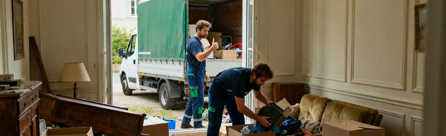 Professionnel en débarras dans un T3 encombré, carton et vieux meubles.