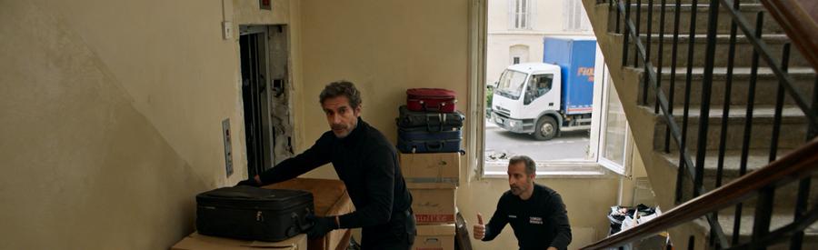 Débarras professionnel dans un couloir étroit d'un immeuble du 15ème arrondissement de Marseille avec des cartons et mobilier à évacuer.