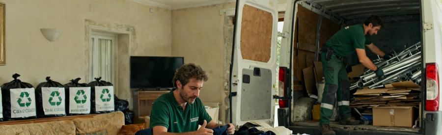 Professionnel sérieux triant des vêtements et objets à Salon-de-Provence avec une camionnette prête pour le recyclage.