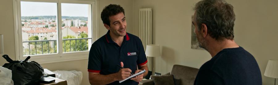 Un débarras professionnel à Ris-Orangis, expert examinant des objets avec un client dans un salon.