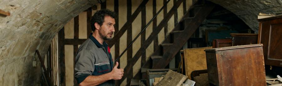 Un professionnel en train d'évaluer des vieux meubles dans une cave d'un appartement ancien à Bayonne.