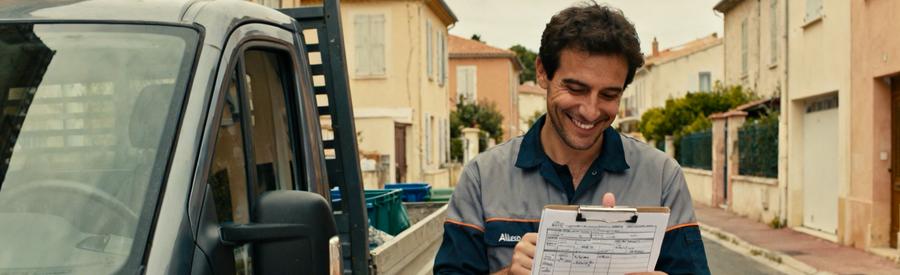 Un professionnel du débarras à Allauch examine un formulaire pour un débarras, accompagné d'une camionnette.