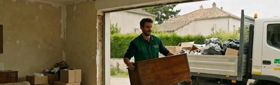 Professionnel débarras retirant des vieux meubles d'un salon à Oullins, devant un camion.