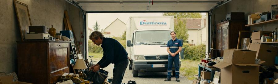 Personne triant des objets dans un garage avant l'arrivée d'un débarrasseur à Vierzon.