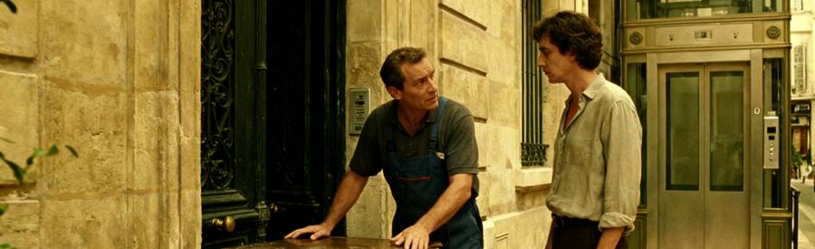 Professionnel du débarras inspectant l'entrée d'un immeuble ancien à Marseille, discutant avec un client.