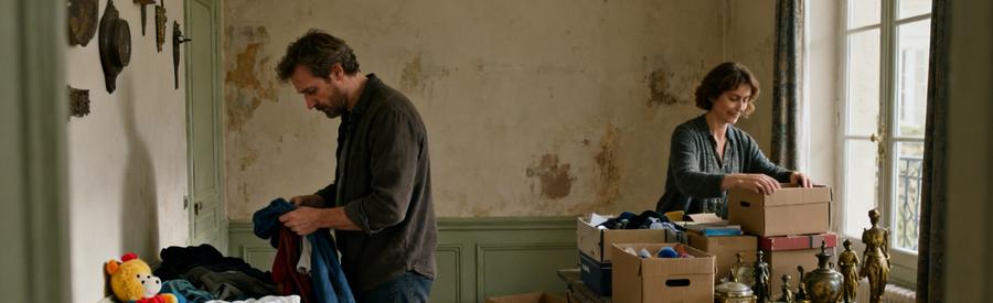 Deux personnes trient des objets dans une maison à Sainte-Geneviève-des-Bois, préparant le débarras.